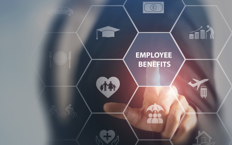 stack of books with employee benefits written on one